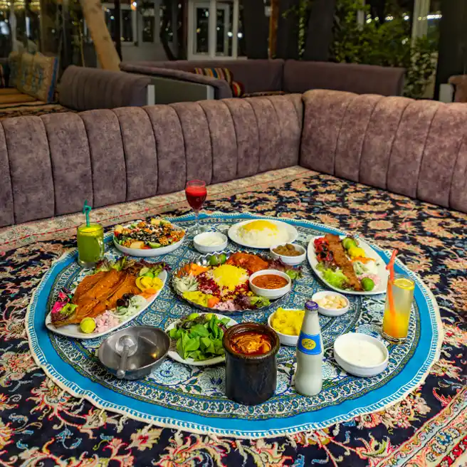 سفره ایرانی با دیزی، کباب، زرشکپلو با مرغ و ماهی قزلآلا در آلاچیق ارکیده شعبه شهریار